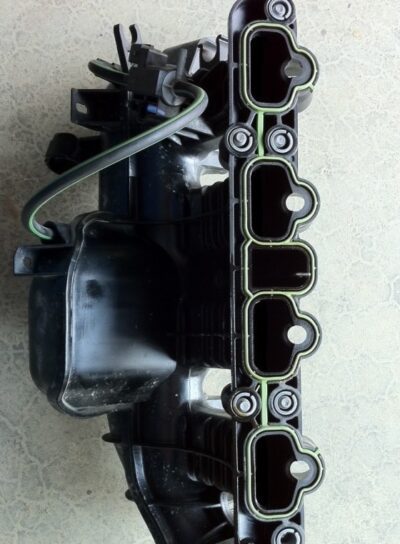 Intake manifold removed from an engine, showcasing the ports and attached sensors and electrical connectors.