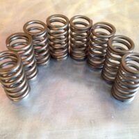 A collection of Upgraded Valve Springs arranged in rows on a metal surface.