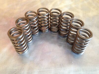 A collection of Upgraded Valve Springs arranged in rows on a metal surface.