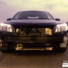 A car with its front bumper removed exposing the radiator and intercooler at dusk.