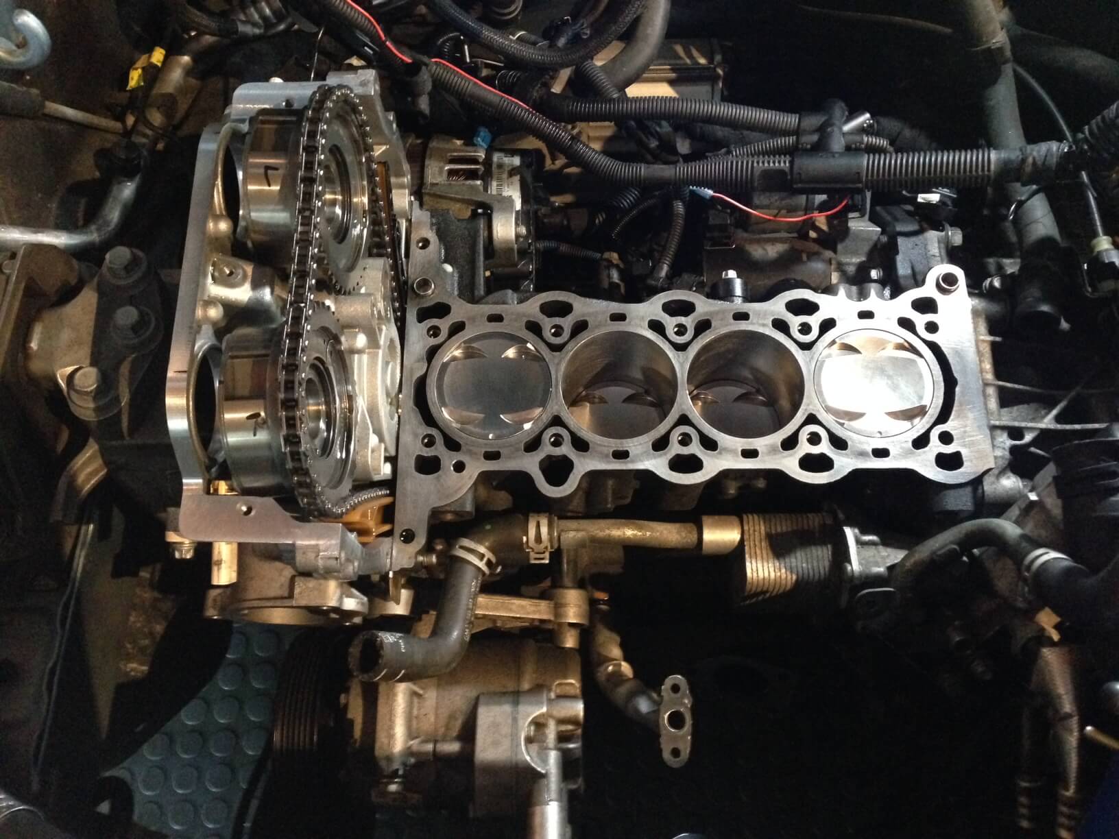 A car engine partially disassembled revealing the cylinder block and pistons.